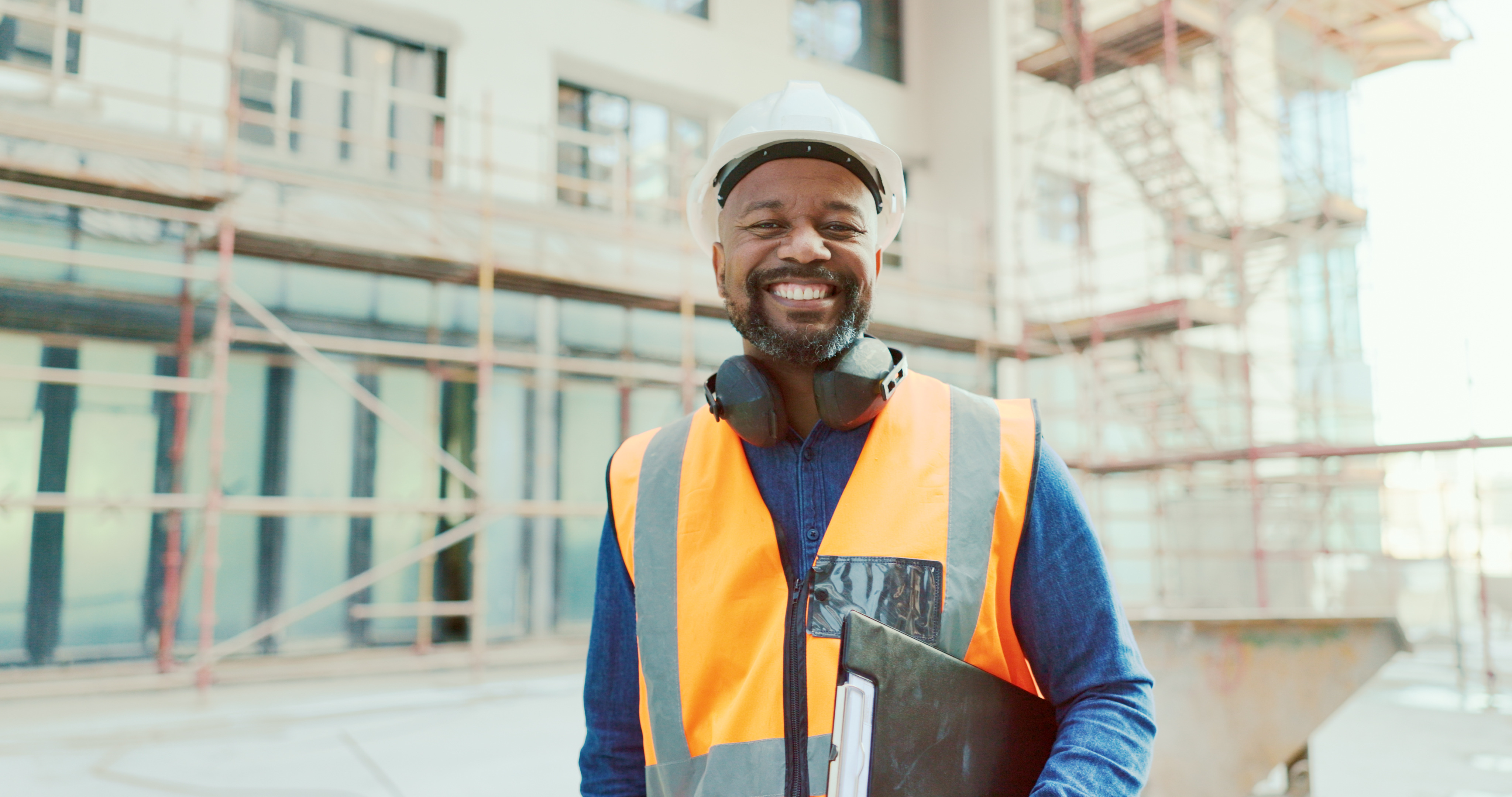 Construction safety representative with clipboard at job site